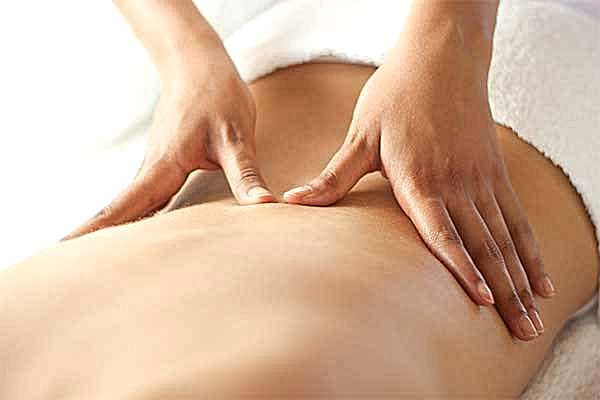 therapist applying massage techniques to a woman's back